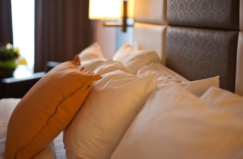 a pile of pillows on a bed in a hotel room at Visitor's Inn in Hamilton