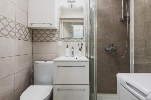 a bathroom with a toilet and a sink and a shower at Mokotowska 67 Prywatne mieszkanie z balkonem w Centrum miasta i w pobliżu Ambasady USA in Warsaw
