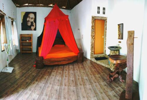 Schlafzimmer mit einem Bett mit rotem Baldachin in der Unterkunft Eriono guest house Bukit lawang in Bukit Lawang
