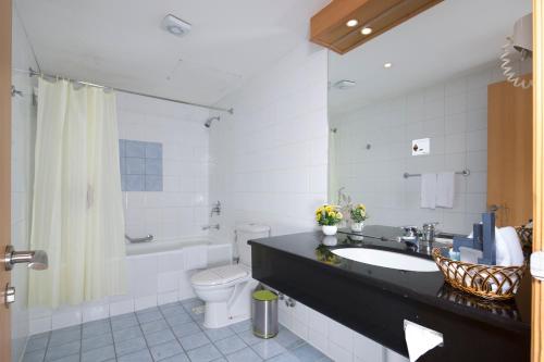 فندق بيسان الدولي في المنامة: حمام مع حوض ومرحاض