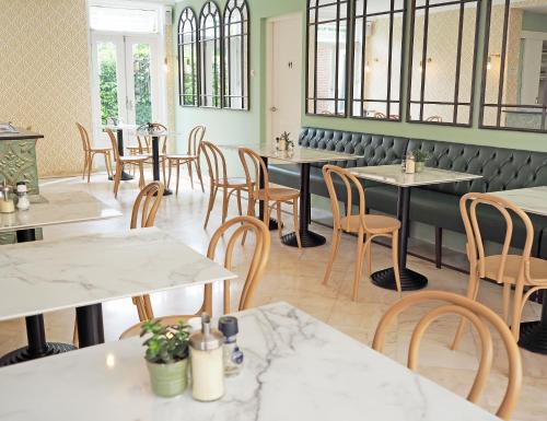 un restaurant avec des tables, des chaises et des fenêtres dans l'établissement Hotel Sebel, à La Haye