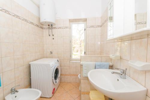 y baño con lavabo y lavadora. en Apartments Grakalic great location, en Medulin