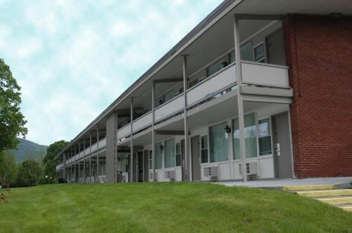 a large brick building with a grass field in front at Fort William Henry Hotel in Lake George