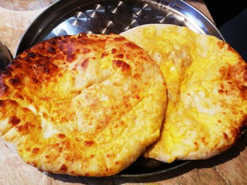 two pizzas sitting on top of a pan at Heshkili huts and cabins Svaneti in Keshkili