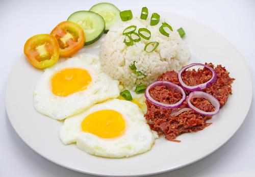 a plate of food with eggs and rice and vegetables at World View Pension House in Dumaguete