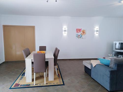ein Wohnzimmer mit einem weißen Tisch und einer Couch in der Unterkunft Casa dos avós in Alvor