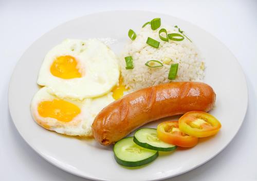a plate of food with rice and a sausage and vegetables at World View Pension House in Dumaguete