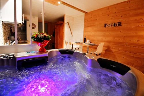 a bath tub with purple water in a room at Le Skidoux in LʼHuez