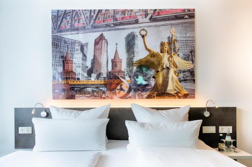 a bed with white pillows and a poster on the wall at Hotel Carolinenhof in Berlin