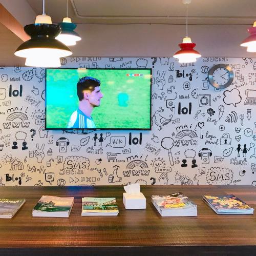 a wall with drawings on it with a tv on it at Single Inn - Taipei in Taipei