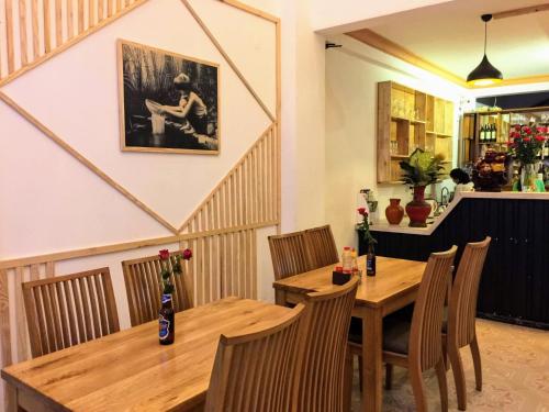 comedor con mesa de madera y sillas en Na Nue Hotel, en Ho Chi Minh