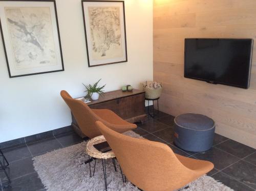 a living room with chairs and a flat screen tv at Poortbossen in Zottegem
