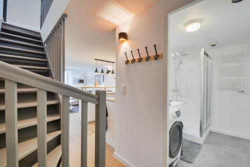 Un escalier mène à une salle de bains pourvue d'un lave-linge. dans l'établissement Le Royal des Trois-Maisons, à Nancy