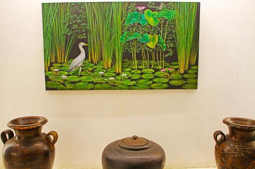 three vases sitting on the floor in front of a painting at World View Pension House in Dumaguete