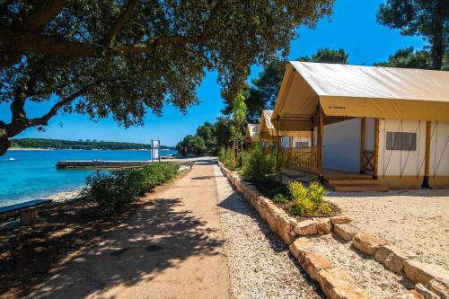 a building next to a body of water at Arena Stoja Camping Homes in Pula