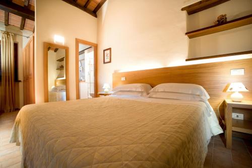 a bedroom with a large bed with two pillows at Guesia Village Hotel e Spa in Foligno