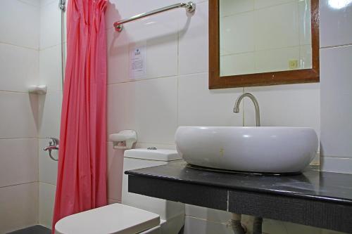 a bathroom with a sink and a toilet and a mirror at World View Pension House in Dumaguete