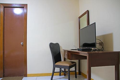 a desk with a computer and a mirror and a chair at World View Pension House in Dumaguete