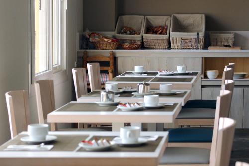 a dining room with tables and chairs with dishes on them at Rocatel in Canet de Mar