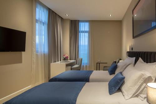 une chambre d'hôtel avec un lit et une télévision dans l'établissement Corona B&B, à Sinj