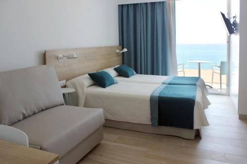 Habitación de hotel con cama y sofá en Rocatel en Canet de Mar