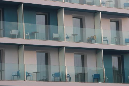a building with chairs and tables in the windows at Rocatel in Canet de Mar