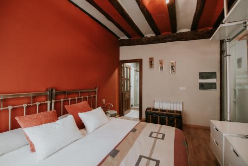 a bedroom with red walls and a bed with white pillows at Haro Apartments in Haro