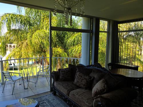 a living room with a couch and a large window at Belurana River Manor in Upington