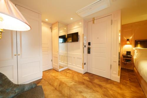 a bedroom with a bed and a dressing room at Mimi's Hotel Soho in London