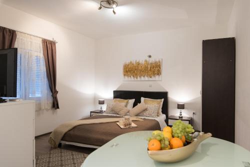 una camera da letto con un letto e una ciotola di frutta su un tavolo di Apartments Nana a Podstrana