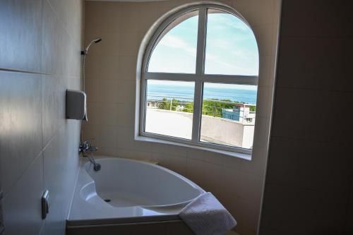 a bathroom with a bath tub and a window at Park hotel Bellevue in Golden Sands