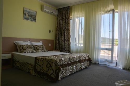 a hotel room with a bed and a large window at Park hotel Bellevue in Golden Sands