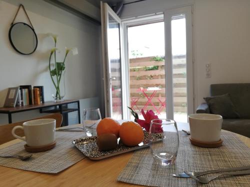 a table with a plate of oranges and glasses on it at Hossegor Les Bécasses in Soorts-Hossegor