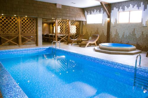a large swimming pool in a room with a house at Russkiy dvor in Izhevsk