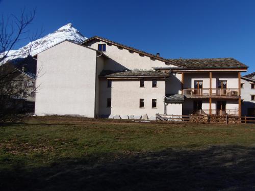 a large white house with a snow covered mountain at Chalet l'aubépine résidence B&B in Bessans