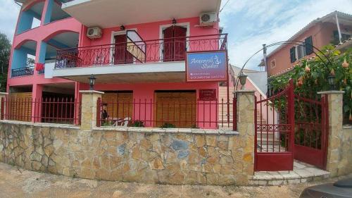 a pink building with a sign in front of it at Araxovoli Studios - Aραξοβόλι Lefkada in Tsoukaladhes