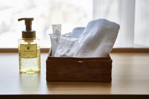 a basket with a bottle of soap and towels at Izumisano Center Hotel Kansai International Airport in Izumi-Sano