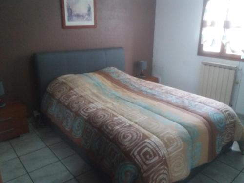 a bedroom with a bed with a colorful blanket on it at villa rue gainekoa 1er étage in Cambo-les-Bains