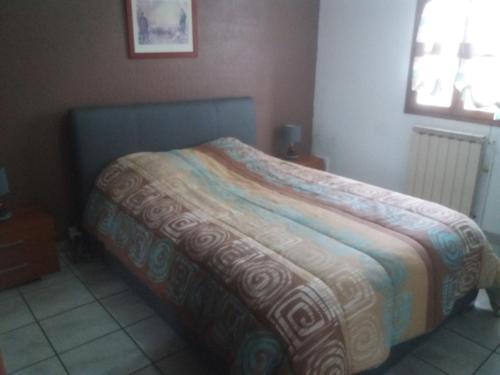 ein Schlafzimmer mit einem Bett mit einer bunten Decke darauf in der Unterkunft villa rue gainekoa 1er étage in Cambo-les-Bains