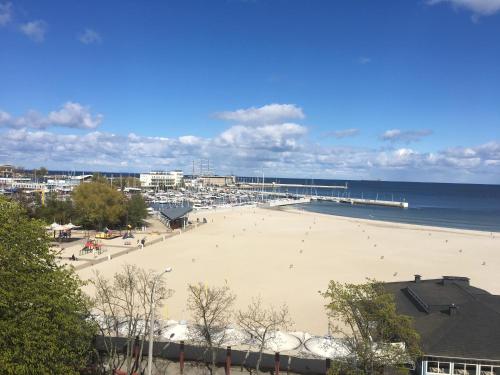 Una vista de una playa con un muelle y el océano. en Apartament Il Capitano, en Gdynia