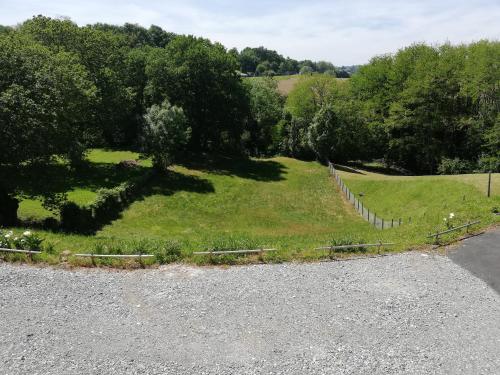 ein großes Grasfeld mit Bäumen und einem Zaun in der Unterkunft villa rue gainekoa 1er étage in Cambo-les-Bains