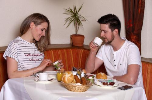 a man and woman sitting at a table eating food at Dorfgasthof Hotel Staberhof in Kellerberg
