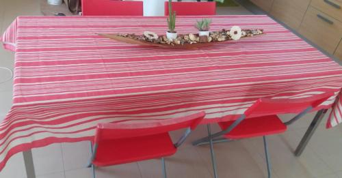 a pink and white striped table with red chairs at Villa A DUE PASSI DAL MARE in Taranto
