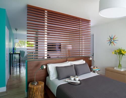 a bedroom with a bed with a wooden headboard at 1818 Meridian House Apartments and Suites by Eskape Collection in Miami Beach