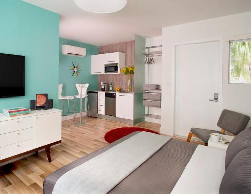a bedroom with a bed and a living room with a tv at 1818 Meridian House Apartments and Suites by Eskape Collection in Miami Beach
