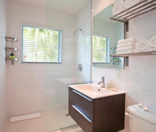 a bathroom with a sink and a toilet and a mirror at 1818 Meridian House Apartments and Suites by Eskape Collection in Miami Beach