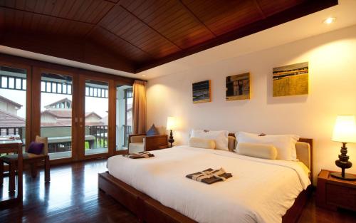 1 dormitorio con cama grande y ventana grande en The Sarann - SHA Extra Plus, en Chaweng Noi Beach