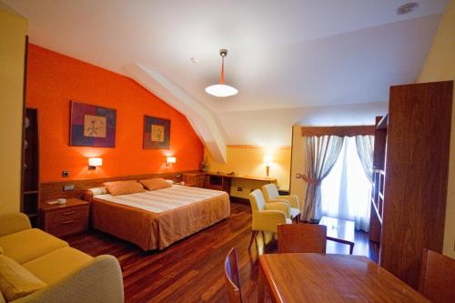 マドリードにあるホテル ロス 5 ピノスのベッド、テーブル、椅子が備わるホテルルームです。