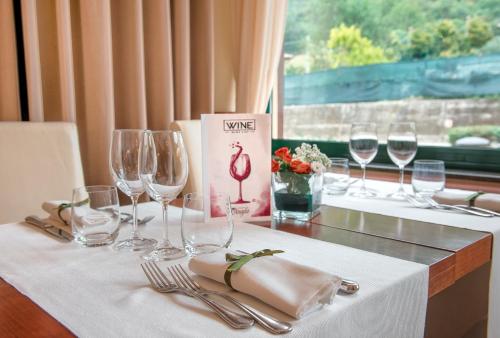 a table with wine glasses and napkins on it at Guesia Village Hotel e Spa in Foligno
