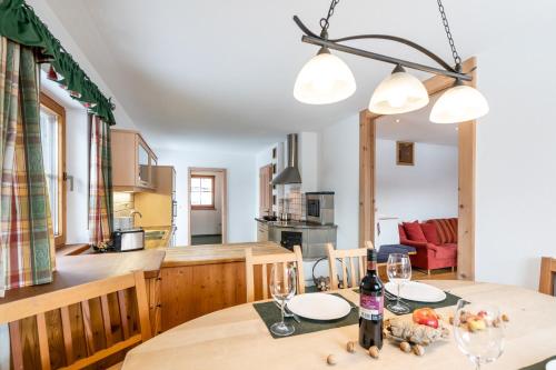 cocina y comedor con mesa y copas de vino en Ferienhaus Mittersill am Biohof Widholz en Mittersill